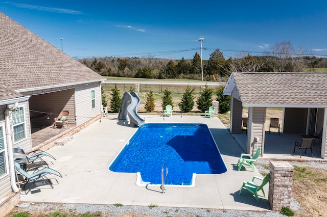 view of swimming pool with a patio area and a water slide