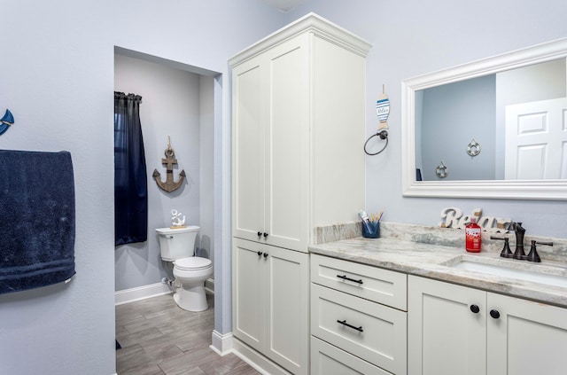 bathroom with vanity, wood-type flooring, and toilet