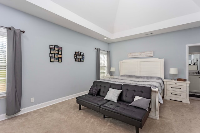 bedroom featuring light carpet and ensuite bath