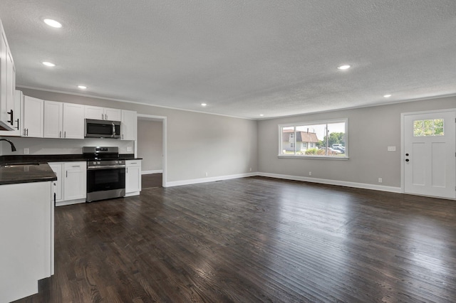 kitchen featuring dark hardwood / wood-style flooring, white cabinets, and stainless steel appliances