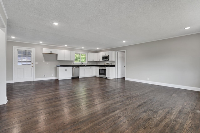 unfurnished living room featuring crown molding, dark hardwood / wood-style flooring, a textured ceiling, and sink