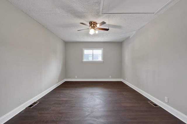 empty room featuring dark hardwood / wood-style floors, ceiling fan, and a textured ceiling