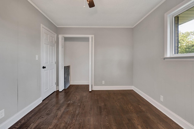 empty room with ceiling fan, dark hardwood / wood-style flooring, a textured ceiling, and crown molding