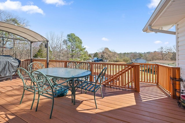 deck featuring outdoor dining space and a grill