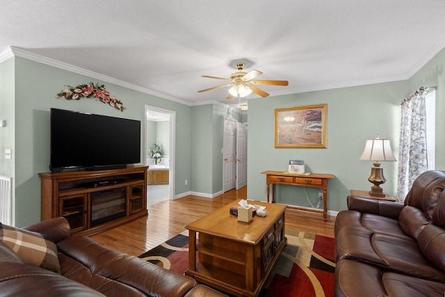 living area featuring a ceiling fan, ornamental molding, and wood finished floors