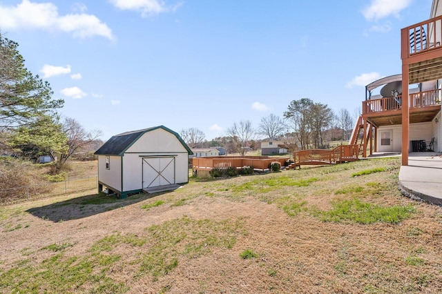 view of yard featuring an outbuilding, fence, a deck, cooling unit, and a shed