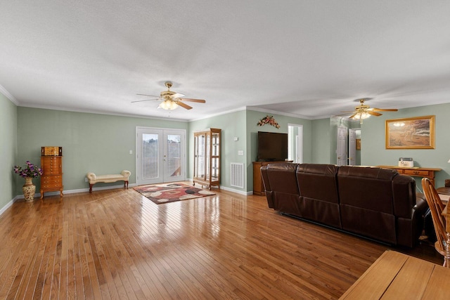 living room featuring ornamental molding, french doors, baseboards, and hardwood / wood-style floors