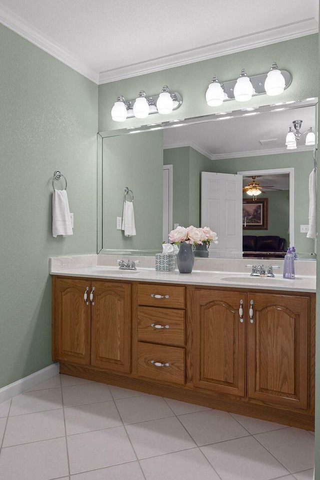 ensuite bathroom with ornamental molding, tile patterned flooring, a sink, and double vanity