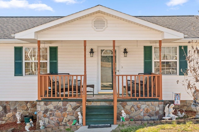 view of front facade featuring a porch and roof with shingles