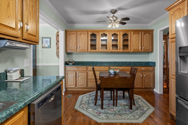 kitchen with appliances with stainless steel finishes, glass insert cabinets, ornamental molding, and dark wood-style floors