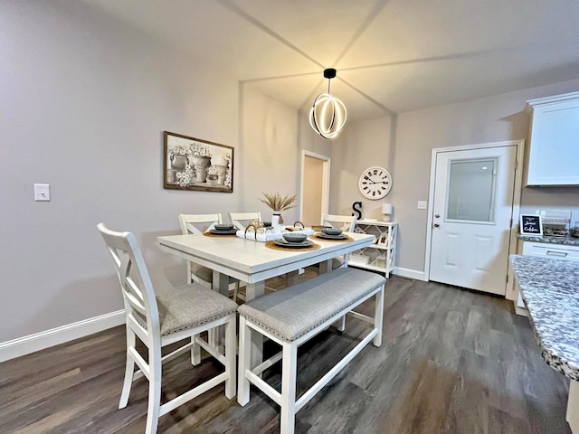dining space featuring baseboards and dark wood-type flooring