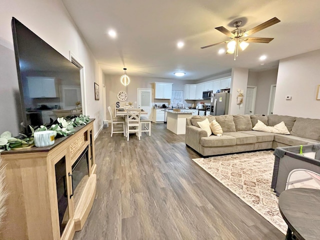 living room featuring dark wood-type flooring, recessed lighting, and ceiling fan