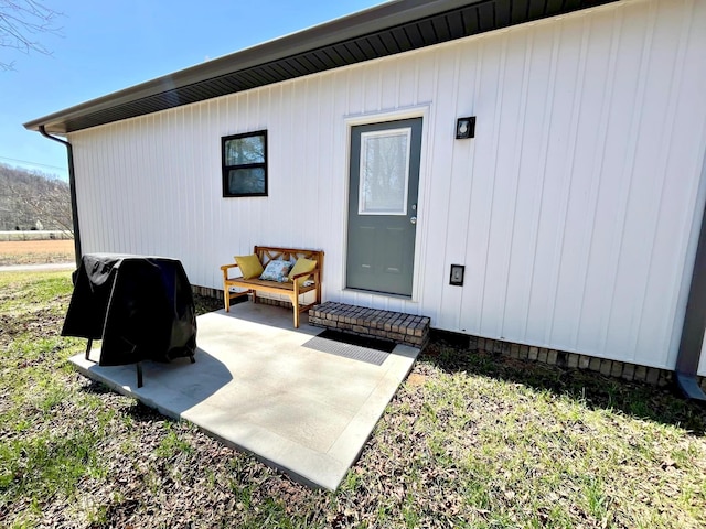 view of exterior entry with a patio