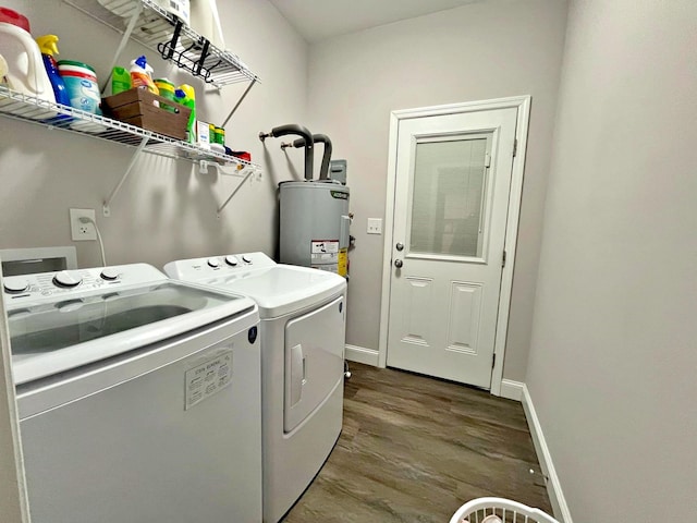 clothes washing area featuring dark wood-type flooring, baseboards, washing machine and dryer, water heater, and laundry area