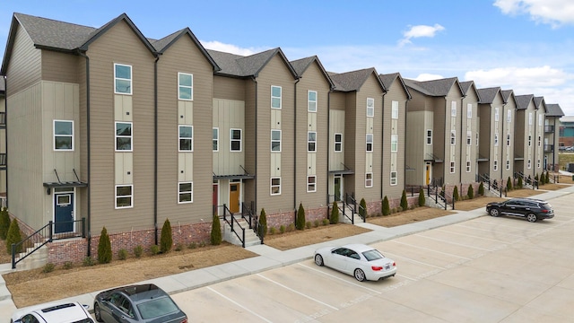 view of property with uncovered parking and a residential view