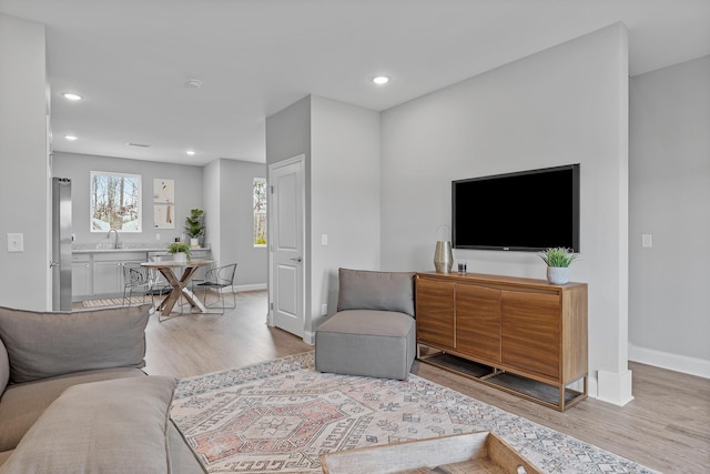 living room featuring light wood-style floors, recessed lighting, and baseboards