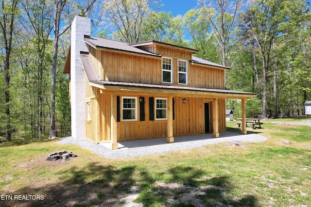 355 Cross Keys Ln, Ten Mile, TN 37880 - view of front of property with a chimney, board and batten siding, metal roof, a front yard, and an outdoor fire pit