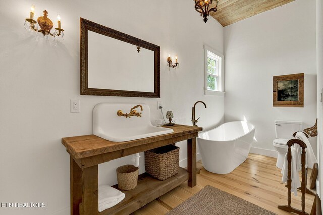 355 Cross Keys Ln, Ten Mile, TN 37880 - bathroom with a sink, baseboards, a freestanding bath, wood finished floors, and vaulted ceiling
