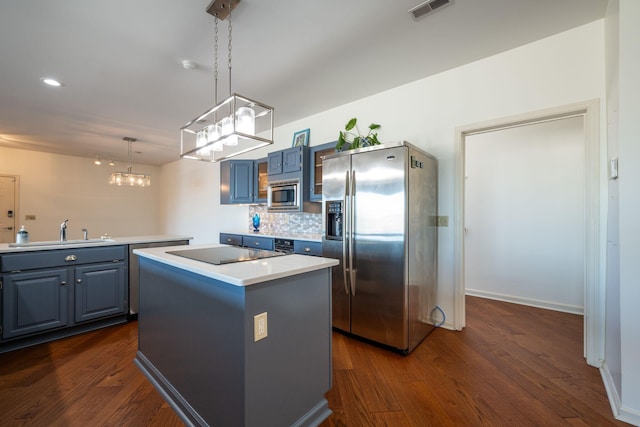 kitchen featuring pendant lighting, a center island, stainless steel appliances, blue cabinetry, and sink