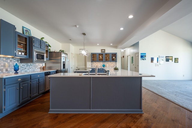 kitchen with sink, blue cabinetry, stainless steel appliances, and a center island with sink