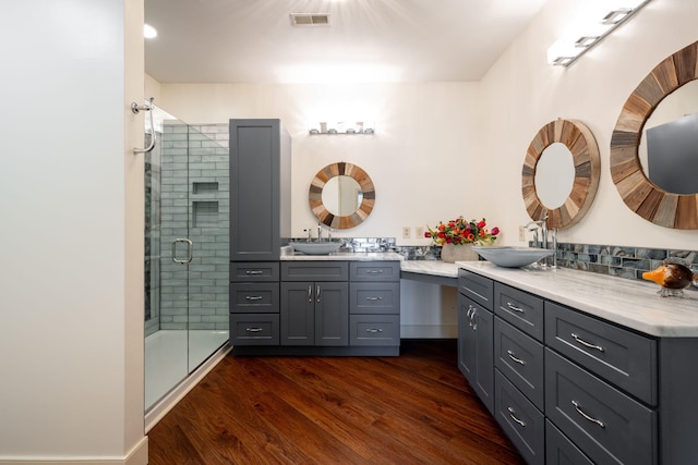 bathroom with a shower with door, hardwood / wood-style floors, and vanity