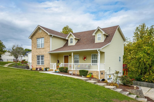 view of front of home featuring a front yard, covered porch, and a shingled roof