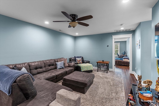 living room with dark wood-type flooring and ceiling fan