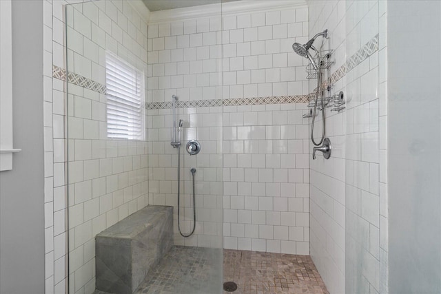 bathroom featuring crown molding and tiled shower