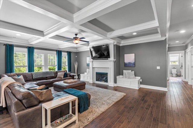 living room with beam ceiling, plenty of natural light, coffered ceiling, ornamental molding, and a large fireplace