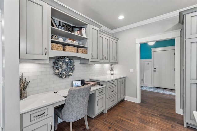 office featuring crown molding, dark hardwood / wood-style flooring, and built in desk