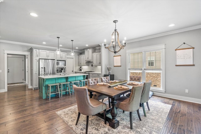 dining space featuring dark hardwood / wood-style flooring, crown molding, sink, and an inviting chandelier