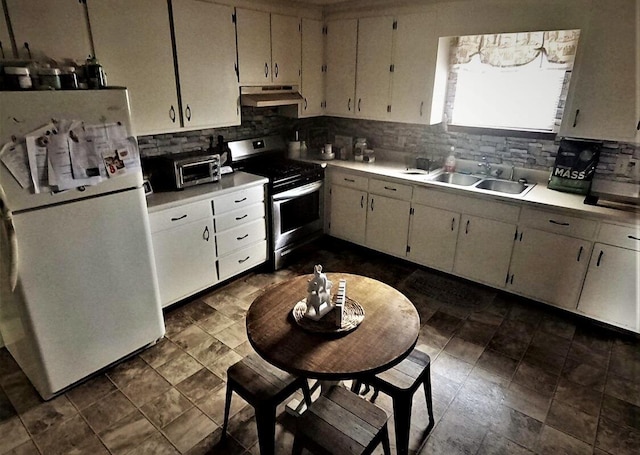 kitchen with tasteful backsplash, sink, white fridge, and stainless steel gas range oven