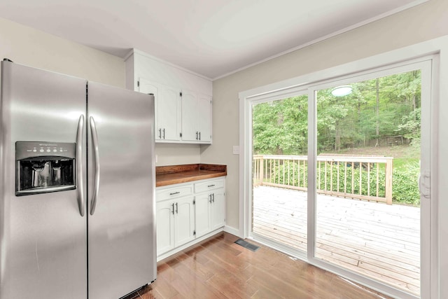 547 Van Davis Rd NW, Georgetown, TN 37336 - kitchen with stainless steel fridge, white cabinets, light wood finished floors, and crown molding