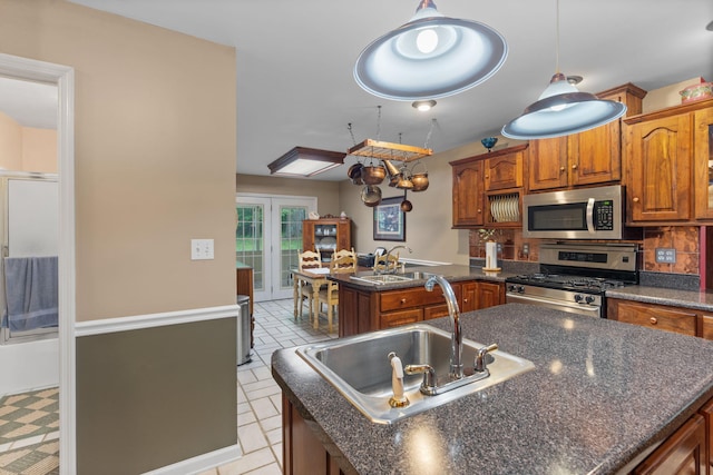 681 Pinhook Rd, Calhoun, TN 37309 - kitchen featuring stainless steel appliances, a peninsula, dark countertops, a sink, and brown cabinets