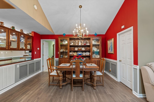 681 Pinhook Rd, Calhoun, TN 37309 - dining space with vaulted ceiling, a chandelier, wood finished floors, a wainscoted wall, and a decorative wall