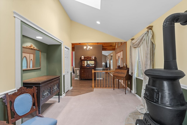 681 Pinhook Rd, Calhoun, TN 37309 - carpeted living area with a chandelier, lofted ceiling, a skylight, a wood stove, and baseboards