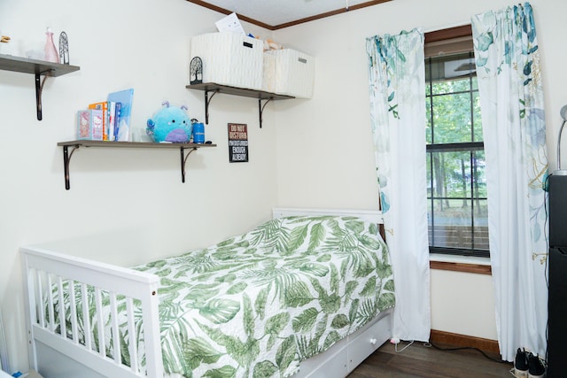 bedroom with dark hardwood / wood-style floors and crown molding