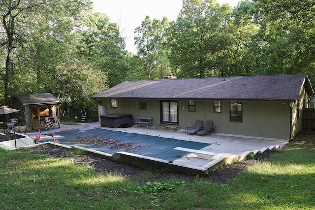 rear view of house featuring a patio area, an outdoor bar, and a hot tub