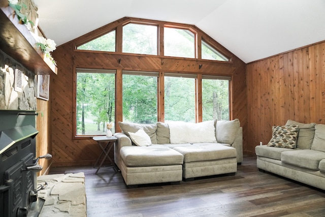 living room with dark wood-type flooring, a healthy amount of sunlight, and vaulted ceiling