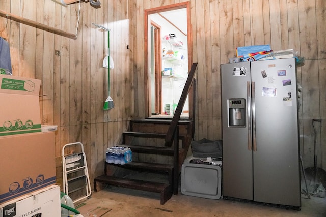 miscellaneous room featuring wood walls and concrete flooring