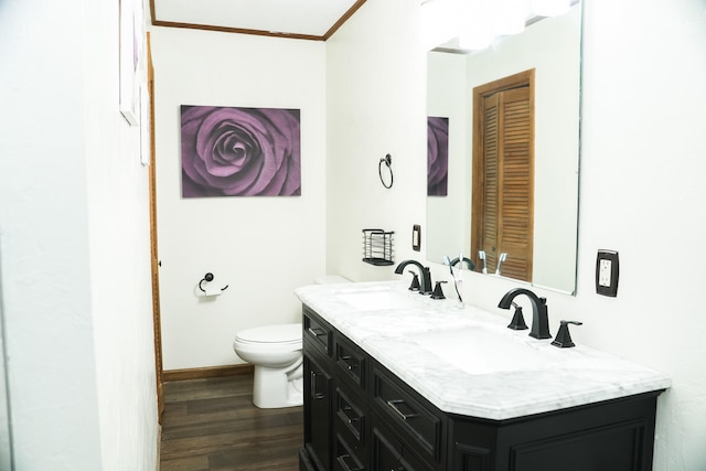 bathroom with wood-type flooring, vanity, toilet, and crown molding