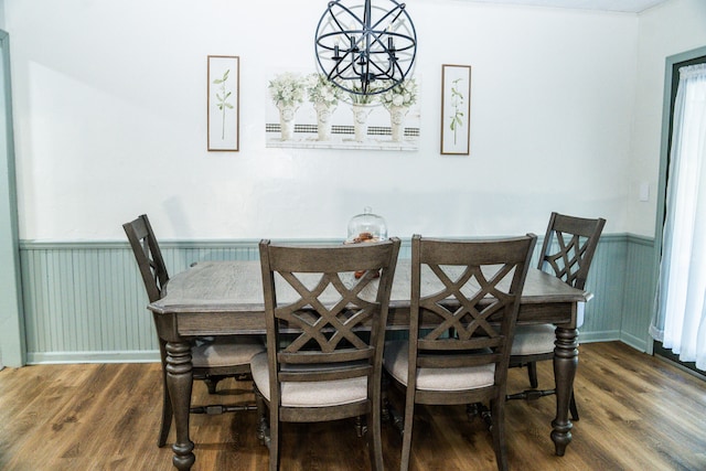 dining space with dark hardwood / wood-style floors and an inviting chandelier