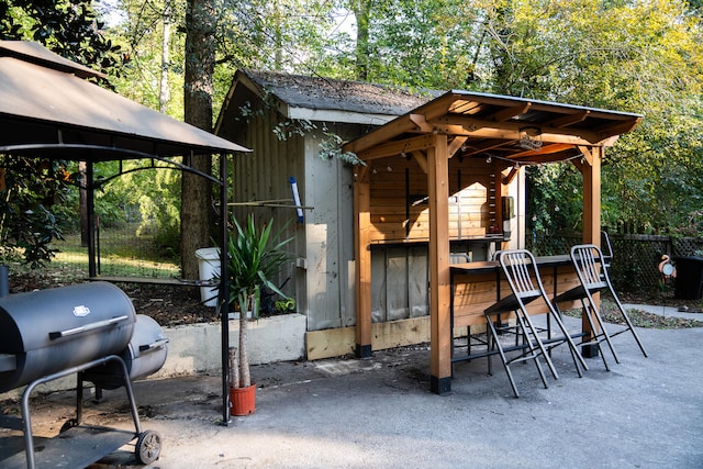 view of patio with area for grilling and an outbuilding