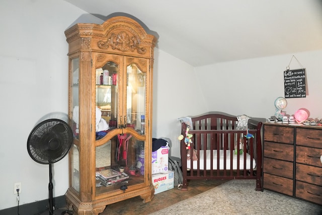 bedroom featuring a crib and vaulted ceiling