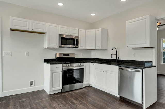 kitchen featuring stainless steel appliances, ceiling fan, dark wood-type flooring, sink, and white cabinets