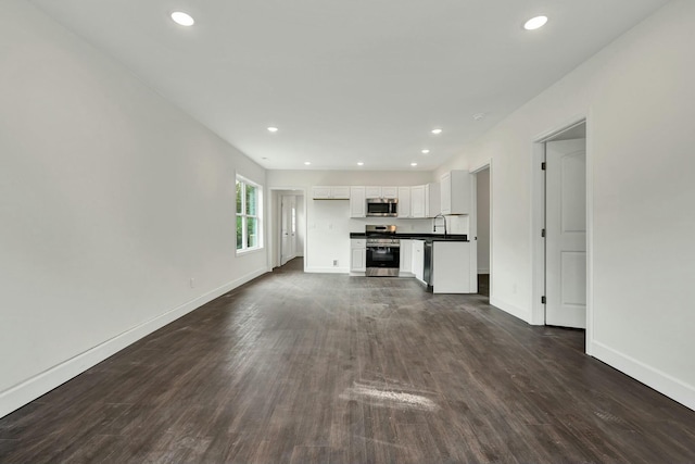 unfurnished living room with dark hardwood / wood-style flooring and sink