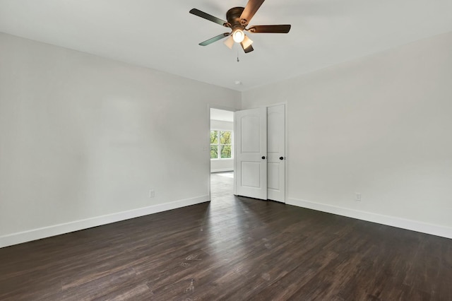 unfurnished room with ceiling fan and dark wood-type flooring