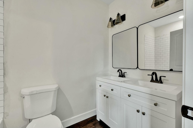 bathroom with hardwood / wood-style floors, vanity, and toilet