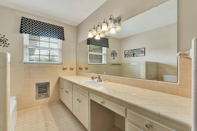 bathroom with tile patterned floors, vanity, heating unit, tile walls, and toilet