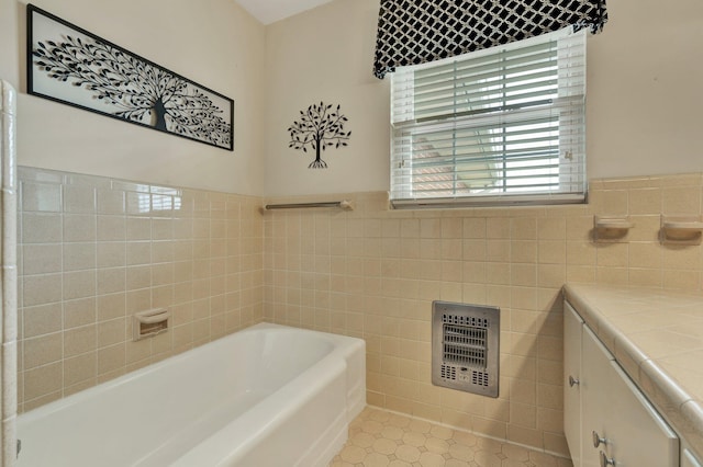 bathroom with vanity, tile patterned floors, tile walls, and a bathing tub